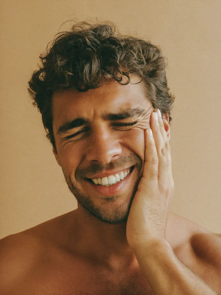Guy holding face indicating tooth pain for emergency dental care at Ora
